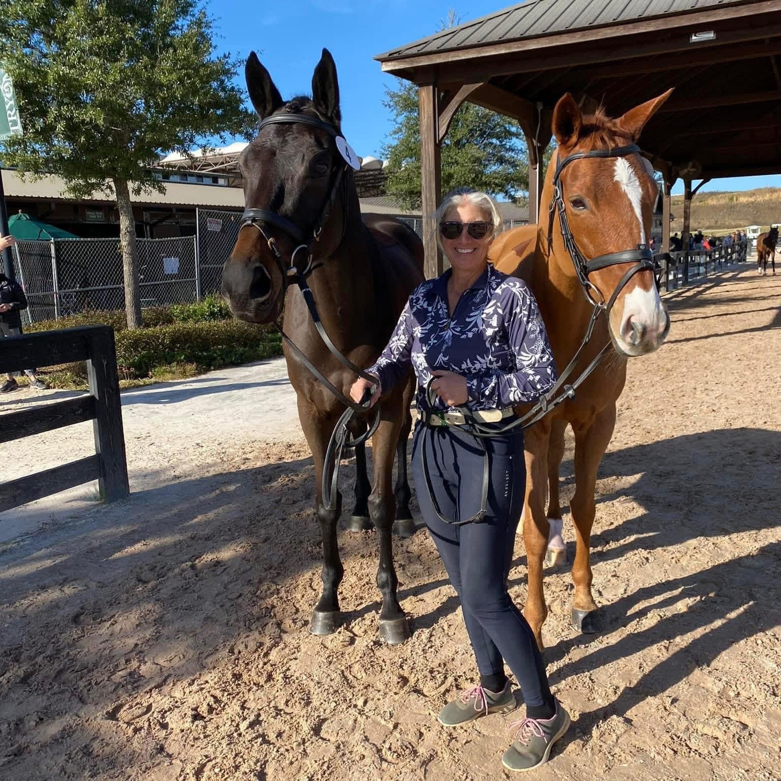 Laura VanderVliet standing with two horses at the farm